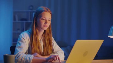 Akşam Masada Oturan Genç Kadın Dizüstü bilgisayar ekranında okuyor. Okuduktan sonra, sessizce ellerini katlayarak dua eder, tanrıların varlığını arar. Huzurlu Ruhani Anlık, İnanç ve İç Yansıma.