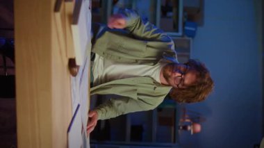 Mimari Planlama. Odaklanmış Profesyonel Adam Dikey Video Biçiminde Büyük Planlar İnceledi. Mimarlık, Mühendislik, Teknik Tasarım ve Kompleks Projelerin Talepleri kavramı.