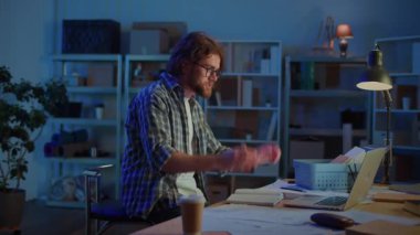 İnternette Gece Masasında Konuşan Adam İçişleri Bakanlığı 'nda ya da Garajda Dizüstü bilgisayar kullanıyor. Uzaktan Çalışma, Çevrimiçi İletişim, Öğrenme, Video Aramaları ve Gece Evden Bağlı Kalma Konsepti.