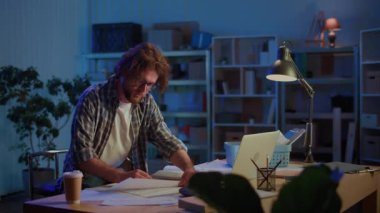 Proje Planlama ve Yaratıcı Çalışmalar. Odaklanmış Adam Garaj Ofisi 'nde Tasarım, Mühendislik, Teknoloji ve Baskı Altındaki İnovasyon Konsepti ile Gece Geç Saatlere Kadar Çalışıyor.