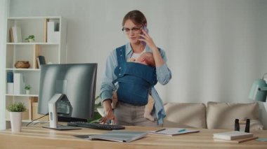 Çeşitlilik ve dahil olma. Modern İşyeri, anneleri, kadın bebek taşıyıcı ve telefonla konuşurken ofis masasında çalışırken destekler..