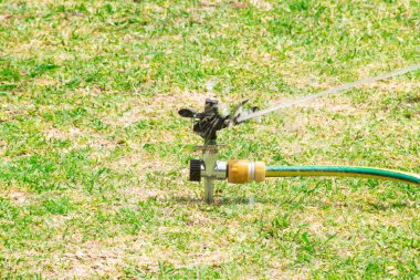 Black garden sprinkler watering with water