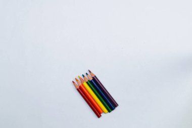 Six pencils of different colors on a light background
