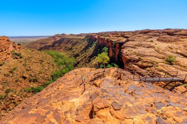 King 's Canyon North duvarının manzarası ve Avustralya' nın kuzeyindeki Watarrka Ulusal Parkı 'nda derin bir yarığı geçen Cotterils Köprüsü' nün arkasındaki yüksek dikey kaya. Outback Kırmızı Merkezi.
