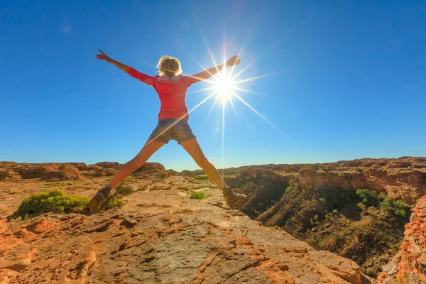 旅行の自由の概念 ハイキングの女の子はレッドセンターアウトバックのキングスキャニオンでジャンプします ワタルカ国立公園の砂岩層の中で 太陽光線で飛び跳ねる オーストラリア中部北部準州 — ストック写真