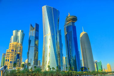 Doha, Katar - 20 Şubat 2019: Al Fardan Kuleleri kompleksi ve Doha Kulesi, Batı Körfezi 'ndeki ikonik yüksek binalar. Orta Doğu 'daki Finans Bölgesi' nin gökdelenleri. Güneşli mavi gökyüzü.