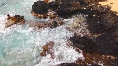 Arka planda bir sürü hareket ve metin için boş bir boşluk olan kayalık bir plaj..