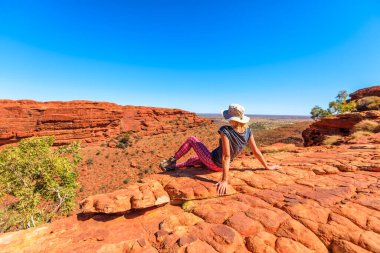 Watarrka Ulusal Parkı, Kuzey Bölgesi NT, Avustralya. Şapkalı turist kadın, Kırmız Merkez 'deki Kings Kanyonu' nun panoramik manzarasına bakıyor..