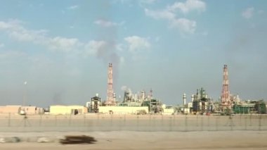 Katar 'daki petrol rafinerisi ve kimya fabrikası. Dumanı yükselen bacaları var. Benzin fiyatı kavramı.