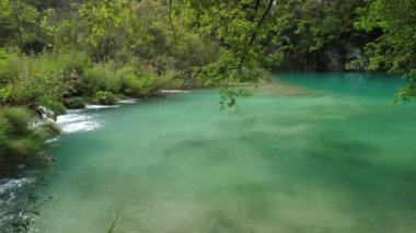Hırvatistan 'ın Lika bölgesindeki Plitvice Lakes Ulusal Parkı' ndaki Milanovac Gölü üzerinde yürüyen iskele köprüsü. Hırvatistan 'ın UNESCO Dünya Mirası Plitvicka Jezera.