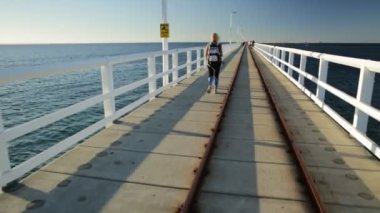 Busselton, Batı Avustralya 'daki Busselton iskelesinde genç ve sportif bir kadın. Dünya Savaşı 'ndaki sembolik ahşap iskelede mutlu bir kadın. Avustralya seyahat ve özgürlük kavramı.