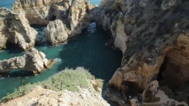 Ponta da Piedade 'a çıkan merdiven. Küçük tekneler için rıhtım kemerler ve doğal mağaralar arasında gezinmek için. Lagos, Algarve, Portekiz 'de keyif çatan turistler.
