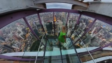 Kız Kuala Lumpur 'un en güzel manzarasının keyfini çıkarıyor. Camiler, tarihi binalar, meydanlar ve alışveriş merkezleri, oteller ve parklar olmak üzere çok sayıda önemli eser ve eser görüyor..