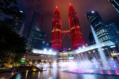 Kuala Lumpur, Malezya - Ocak 2023: Gece çökerken, Petronas İkiz Kuleleri, aydınlık pınarları parıldamaya ve hareket etmeye başlayan karanlık gökyüzüne karşı çarpıcı bir ana hat oluşturur..