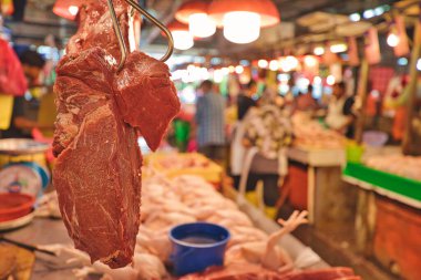 Kuala Lumpurs Chow Kit Road Market 'teki kasaplığa ayrıntılı bir bakış. Tedarikçilerin bağırıp çağırdığı ve alıcıların tezgahların arasından geçtiği hareketli bir ticaret merkezi..