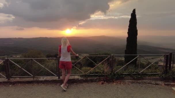 在Tuscany Winegrowing村的Montalcino度假旅行的无忧无虑的女人 意大利葡萄园中的塔斯坎山和日落时著名的葡萄酒产区 意大利托斯卡纳地区 — 图库视频影像