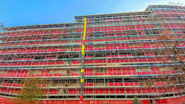 İnşaattaki yapı desteği için yapı iskelesi. Evin yenilenmesi için bir yapı iskelesinin ön görüntüsü. İşçiler için çalışma platformu.