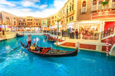Macau, Çin - 9 Aralık 2016: Bir gondolcu turistleri Venedik Lüks Otel ve Kumarhanesi ve Macau 'daki alışveriş merkezlerinde romantik bir yolculuğa çıkarıyor.