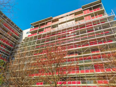 Bir binanın yapımını desteklemek için kullanılan yapı iskelesi. Konut yenileme veya diğer inşaat projeleri sırasında işçiler için çalışma platformu sağlıyor.