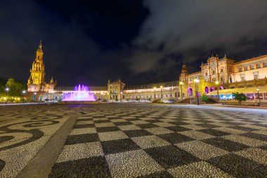 İspanya 'nın Sevilla şehrinin Plaza de Espana' sında gece vakti menekşe renkli hareketli suyla çeşme aydınlandı..