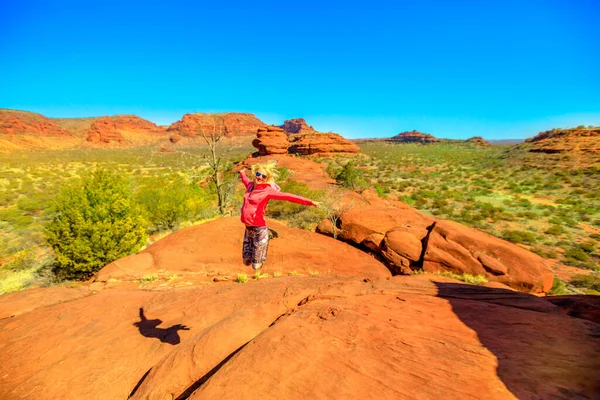 stock image Kalaranga Lookout in Finke Gorge National Park, Northern Territory, Central Australia. Active woman jumping atop of hiking. Aerial view of red sandstone amphitheatre. Red Centre Outback.