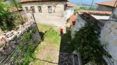 Berat şehrini ziyaret eden bir kız turistin havadan görünüşü, esasen Osmanlı mimarisinin istisnai örnekleri ve eşsiz kentsel düzeni için UNESCO Dünya Mirası Alanı.