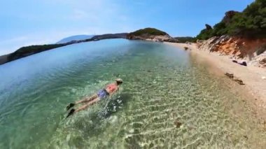 Ksamil Adaları 'nda yüzen kızın drone görüntüsü. Popüler turizm merkezi, özellikle de yaz aylarında..