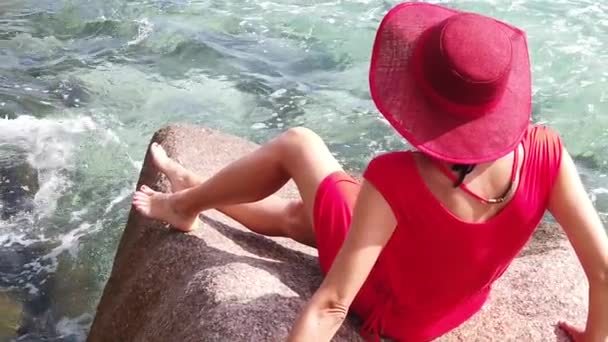 慢动作 穿着红色礼服的快乐旅游女性 从花岗岩的石头上看着安塞严重海滩 拉迪格 塞舌尔 印度洋 女性生活方式在热带享受暑假 — 图库视频影像