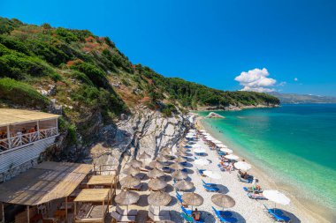 Arnavutluk 'un Saranda kenti - 6 Haziran 2023: Arnavutluk' taki Pulebardha Plajı rahatlatıcı bir plaj kaçamağı için huzurlu ve huzurlu bir ortam sunuyor. Yukarıdan bir manzara bu kıyı cennetinin nefes kesici güzelliğini gözler önüne seriyor.