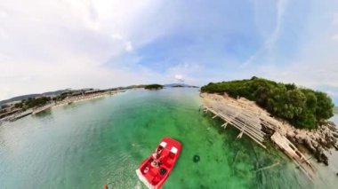 Ksamil Adaları 'nda sakin bir tekne gezisindeki çift. Turkuaz sularda nazikçe pedal çeviriyorlar, sıcak güneşin tadını çıkarıyorlar ve Arnavutluk 'taki gizli koyları ve pitoresk plajları keşfediyorlar. DRone görüntüsü