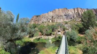 Türkiye Kapadokya 'daki Ihlara Vadisi. Ihlara Vadisi Melendiz Nehri tarafından oyulmuştur ve 100 metre yüksekliğe kadar yükselen kaya kayalıkları ve manzarasını noktalayan kaya kesimli kiliseler barındırır.
