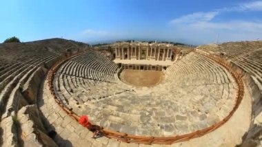 Hierapolis Tiyatrosu 'ndaki kadın turist zarif tasarımı, akustik mükemmelliği ve tarihsel önemi ile antik Türkiye' yi keşfeden tarih meraklıları ve gezginleri için büyüleyici bir yer.