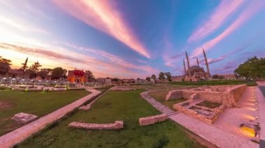 Edirne, çarpıcı şehir manzaralı hindi akşamı. Eski Ulu Eski Camii ve Selimiye Camii 'nin günbatımında altın sarısı renkler, Mimar Sinan heykeli ve Edirne Belediye Binası' nın zarif varlığıyla çerçevelenmiş.