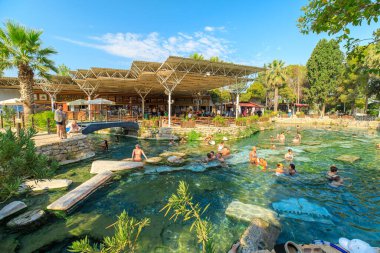 Pamukkale, Türkiye - 7 Ağustos 2023: Turistler, Türkiye 'deki Hierapolis Kleopatra Havuzları' nın canlandırıcı sularından keyif alarak antik çağlardaki cazibe ortamında terapi deneyimini kucaklıyor.