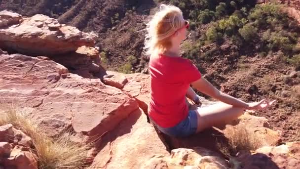 ロータスでヨガ瞑想をしている平和な女性は ウォーターカ国立公園のキングスキャニオン Kings Canyon の端に 正面に垂直な岩壁がある アウトバックレッドセンター ノーザンテリトリー オーストラリア — ストック動画