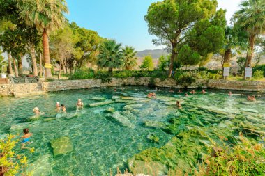 Pamukkale, Türkiye - 7 Ağustos 2023: Turistler, Hierapolis 'teki Kleopatra Havuzları' nın termal sularını yeniden canlandırmaya, büyüleyici antik cazibe ortamında huzur verici deneyimler yaşamaya,.