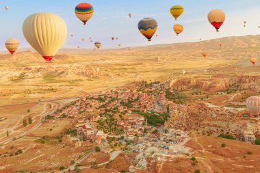 Balonlar Cappadocias 'ın uçsuz bucaksız siluetine. Balonların parlak renkleri giderek azalan gün ışığını yakalayarak, Türkiye 'deki Goreme, Kapadokya' daki gerçeküstü zirvelerde büyüleyici bir aydınlanma yaratıyor..