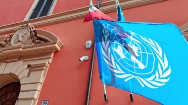 Bologna, İtalya - 27 Ekim 2023: Birleşmiş Milletler bayrağı, Avrupa bayrağı ve İtalyan üç renkli bayrağı, dAzeglio Caddesi, 56 numaradaki Bologna Adliyesi Suç Bölümünde belirgin bir şekilde sergilenmektedir..