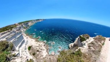 Drone view from mount Leone of the Bonifacio bay with Secret Beach and King Aragon Steps. Aerial view of the cliffs on the Bonifacio French town in Corsica island of France in Mediterranean sea.