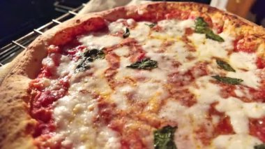 Domates, mozzarella ve fesleğen yapraklarıyla kaplı bir Margherita pizzası pişirme sürecinde. Köpürürken pizza sosunun yakından görüntüsü. İtalya 'dan bir tarif..