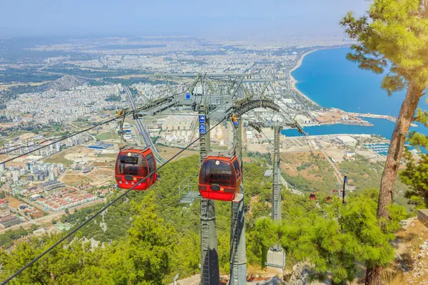 Türkiye 'nin Antalya kentinin pitoresk manzarasında, dinamik kırmızı bir teleferik zarafetle yükseliyor. Tunektepe dağ zirvesinin zemininde, deniz seviyesinden 605 metre yüksekte, panorama açılır..