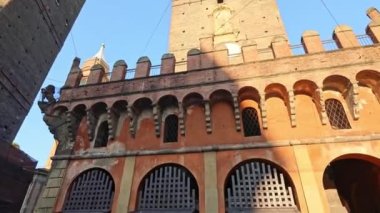 Aşağıdan bakan Bologna 'nın iki kulesi, İtalya' nın mavi gökyüzüne karşı şehrin simgesi. Asinelli ve Garisenda kuleleri tarihi şehir merkezinde Porta Ravegnana meydanındaki saat kulesinin yanında dimdik duruyorlar.