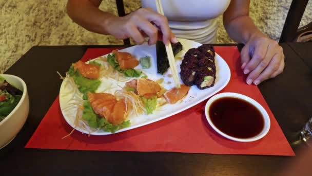 세련된 여자는 식당에서 사시미와 우라마키 즐긴다 신선하고 가벼운 식사의 다이어트를 — 비디오
