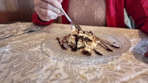 スローモーション チョコレートケーキのデザートにふけっている女性 彼女は イタリアのレストランでスプーンを使用して チョコレートで振りかける 多層ケーキの魅力的な作品をリリースします — ストック動画