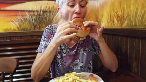 Mulher Moderna Deliciando Com Sabor Salgado Cheeseburger Seus Sucos Misturados — Vídeo de Stock