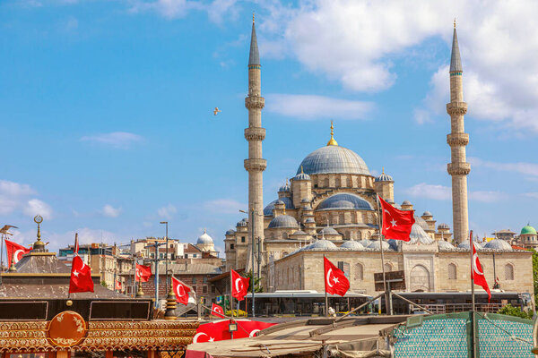 Gazing across Bosphorus Strait, New Mosque of Istanbul stands as majestic silhouette against cityscape. with its twin minarets and grand dome. Testament to Ottoman era, reflect gracefully on the sea