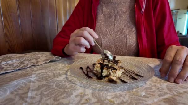 Slow Motion イタリアのレストランでチョコレートで飾られたレイヤーケーキのスライスを楽しんでいます 彼女の手のスプーンはデザートの抵抗できない魅力的な魅力を示唆しています — ストック動画
