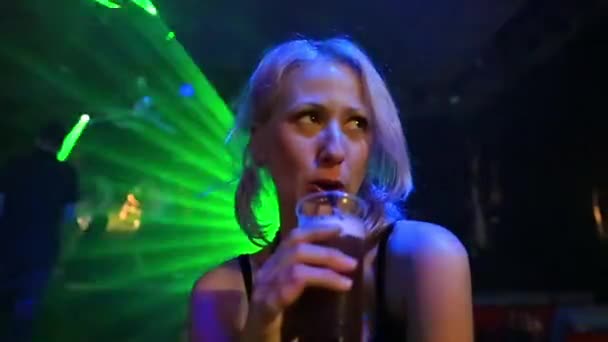Потрясающая Блондинка Пьет Смешанный Напиток Тускло Освещенном Танцевальном Клубе Сине — стоковое видео