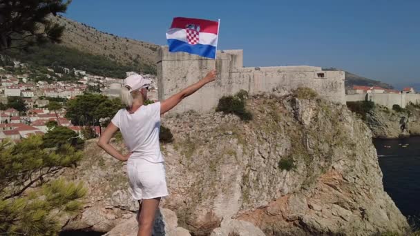 慢动作 在克罗地亚的Dubrovnik要塞Lovrijenac 女孩与Bokar堡一起举着克罗地亚国旗 杜布罗夫尼克教科文组织世界遗产所在地是克罗地亚达尔马提亚的一个古老的威尼斯城市 — 图库视频影像