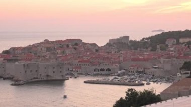 Hırvatistan 'ın Dubrovnik kentinin eski ortaçağ limanının günbatımı hava manzarası. Dalmaçya 'nın tarihi Hırvatistan kenti Dubrovnik. UNESCO Venedik mimarisi. Arka planda Fort Lovrijenac kalesi